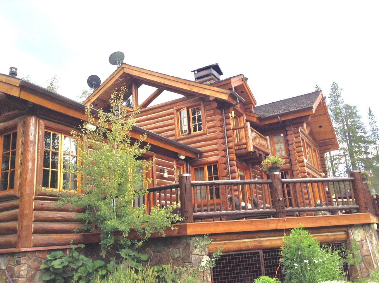 Close view of restained log walls, railings and window trim on a log home